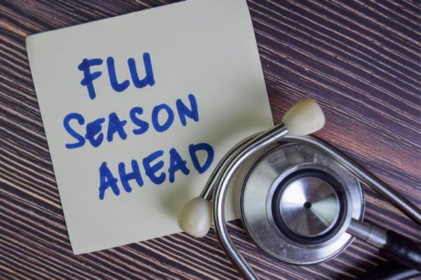 Post-it note and stethoscope with writing 'flu season ahead'